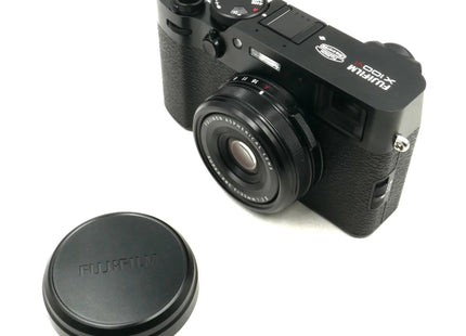 Fujifilm X100VI, black, front angled view with lens cap beside camera