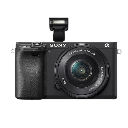 Sony Alpha 6400K, black, angled front view with flash raised and kit lens