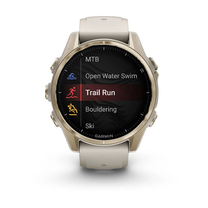 Garmin Fenix 8 Smartwatch, Soft Gold bezel with Fog Gray band, front view, display on showing activity menu